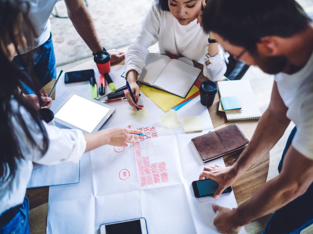 Distintas personas de un equipo juntan ideas para efectuar su estrategia de marketing digital.