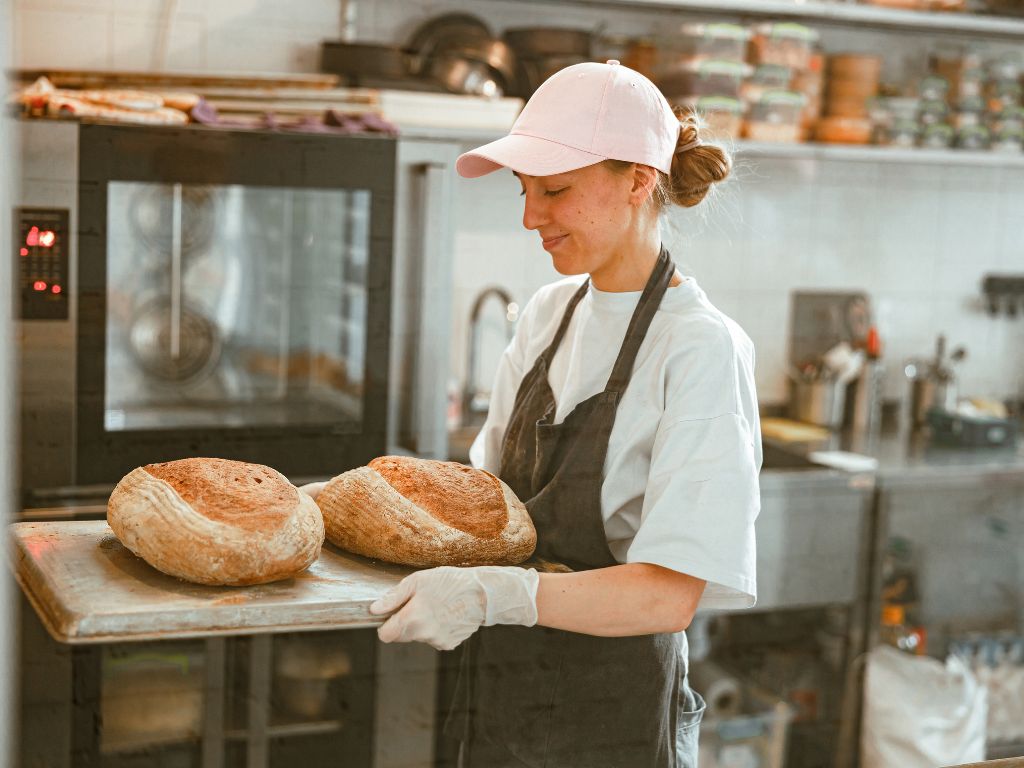 Mujer trabajando en su pyme de panadería. Se encuentra en búsqueda de financiamiento para pyme para potenciar su negocio. 