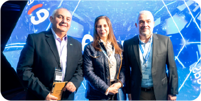 Tres asistentes al evento Gira Entel Empresas 2026 en Temuco posando frente a la pantalla digital del evento.