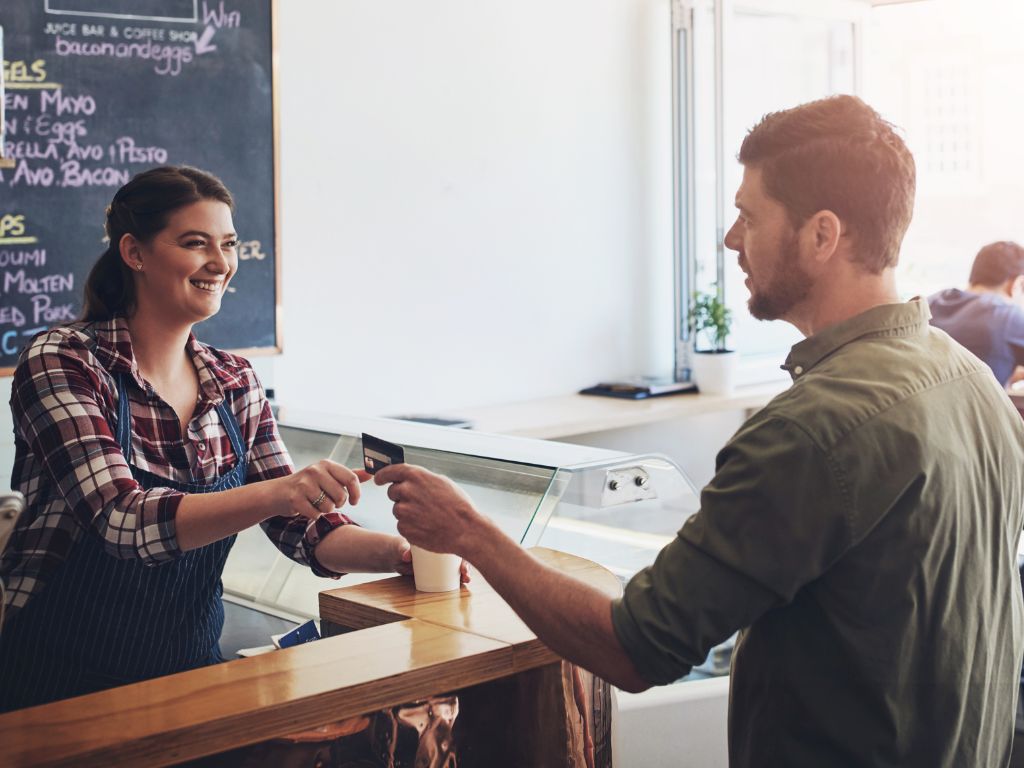 Una mujer atendiendo su negocio. Genera un vínculo cercano con su cliente, a propósito de la estrategia de marketing relacional que está llevando a cabo. 